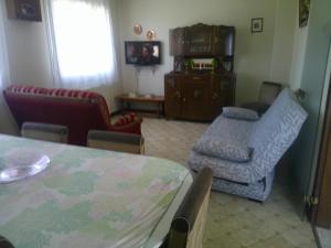 a living room with a couch and a chair and a table at le pavillon a la campagne in La Perche