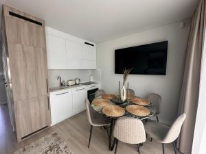 een keuken en eetkamer met een tafel en stoelen bij Monci Resort in Palanga