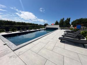 een zwembad met ligstoelen op een patio bij Monci Resort in Palanga