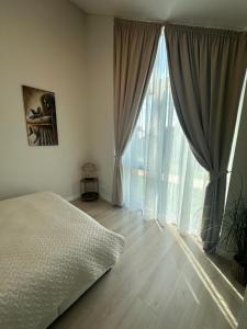 een slaapkamer met een bed en een groot raam bij Monci Resort in Palanga +23 foto's