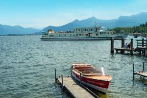 a boat docked at a dock with a large boat at Ferienwohnung mit Garten am Chiemsee in Prien am Chiemsee