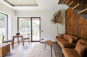 ein Wohnzimmer mit Sofa und Tisch in der Unterkunft Kotedžas prie jūros in Palanga