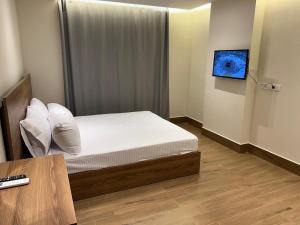 a bedroom with a bed and a tv on a wall at Sun gate house in Cairo