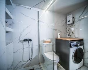 a bathroom with a toilet and a washing machine at Loft Lux Living - 7 minutes from Volos Center in Volos