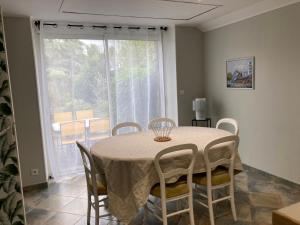 ein Esszimmer mit Tisch und Stühlen und einem Fenster in der Unterkunft Maison proche mer in Agon Coutainville