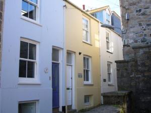 a row of buildings with a blue door on a street at Mermaids Rest in St Ives