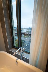 a bathroom with a tub and a window with a view at Clayton Hotel Glasgow City in Glasgow