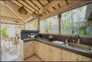 a kitchen with a sink and a large window at Villa Ramara in Munggu +3 photos