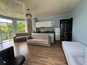 a living room with a couch and a kitchen at Royal House in Kvariati