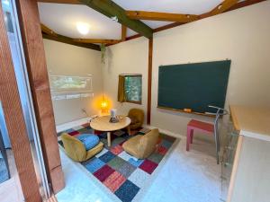 ein Wohnzimmer mit Fernseher und Tisch und Stühlen in der Unterkunft S-villa Nasu Candy in Nasu + 24 Fotos