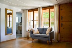 a living room with a chair and a mirror at Swiss Mountain-Valley View Lodge in Erlenbach im Simmental