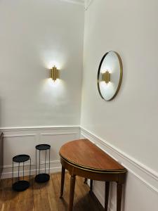 a room with a table and two stools and a mirror at Appartement Porte Mars 1 Reims Arena gare centre in Reims
