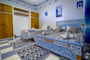 two beds in a room with blue and white at Casa Voyager 'secret garden terrace' in Chefchaouen +37 photos