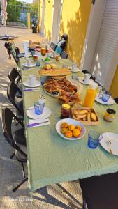 a long green table with plates of food on it at Madame in Clérey