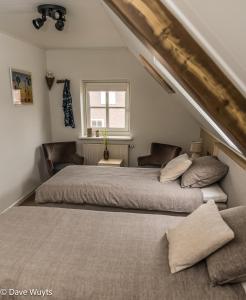 two beds in a bedroom with an attic at Onder De Wolfskap bed en ontbijt in Haaren