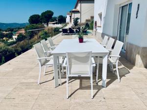 a white dining table and chairs on a balcony at Hauzify I Casa Gaditana in Santa Cristina d'Aro
