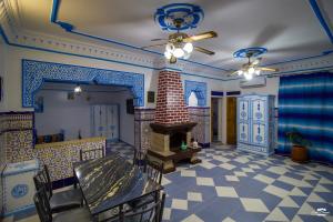 a living room with a fireplace and blue and white tiles at Casa Voyager 'secret garden terrace' in Chefchaouen