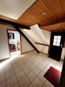 an attic room with a wooden ceiling and a red rug at Fewo in Zell-Merl in Zell an der Mosel