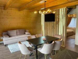 a living room with a table and chairs and a couch at Casa Belvedere Pietrosu in Moisei
