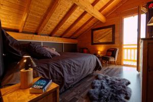 a bedroom with a bed in a wooden cabin at Chalet d'exception, spa et sauna, 4p in La Bresse