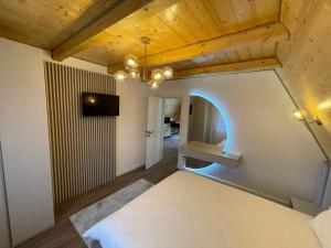 a room with a bed and a tv on a wall at Casa Belvedere Pietrosu in Moisei