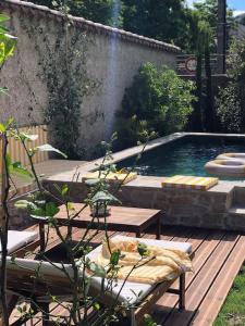 ein Pool mit einer Holzterrasse und einer Bank daneben in der Unterkunft Charmante Grange aux Monts d'Or in Collonges-au-Mont-dʼOr