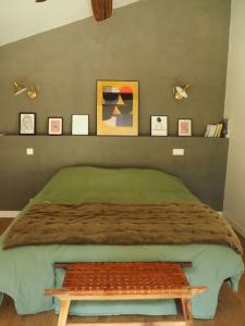 ein Schlafzimmer mit einem Bett mit einer Bank darauf in der Unterkunft Charmante Grange aux Monts d'Or in Collonges-au-Mont-dʼOr