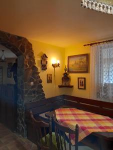 a living room with a table and a stone fireplace at Panzio Anett in Pietroasa