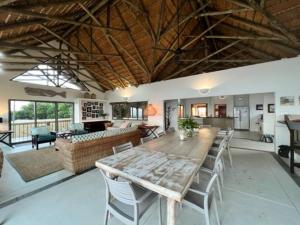 a large living room with a wooden table and chairs at Kangela 6 in Ponta Malangane