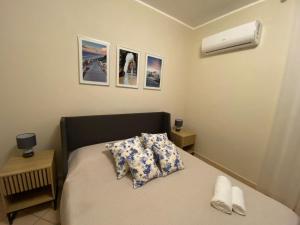 een slaapkamer met een bed met twee kussens en een kachel bij Viki House Mazara in Mazara del Vallo +80 foto's