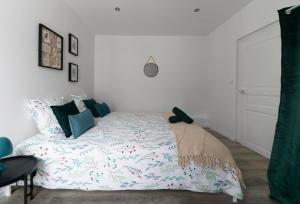 a bed in a bedroom with a white wall at Résidence Le Celest - Appartements climatisés - Centre ville in Vichy