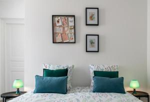 a bedroom with a bed and three pictures on the wall at Résidence Le Celest - Appartements climatisés - Centre ville in Vichy