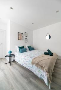 a white bedroom with a bed and a table at Résidence Le Celest - Appartements climatisés - Centre ville in Vichy