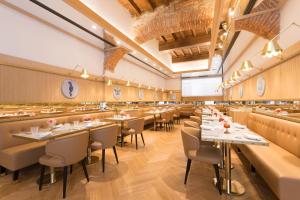 a restaurant with tables and chairs in a room at IL Tornabuoni The Unbound Collection by Hyatt in Florence