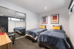 Un dormitorio con dos camas y un espejo. en Chic Beach Studio, en Rye