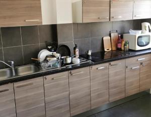 a kitchen with a sink and a microwave at Chambre cœur du centre-ville in Le Havre +14 photos