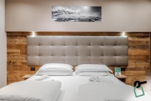 a bedroom with two beds and a large headboard at Hotiday Sauze Assietta in Sauze dʼOulx