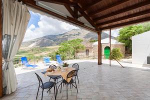 a patio with a table and chairs and mountains at Case Navarra in Balata di Baida