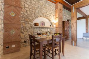 a kitchen with a wooden table and a stone wall at Case Navarra in Balata di Baida