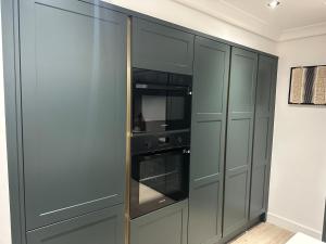 a kitchen with gray cabinets and an oven at Ocean Breeze Apartment in Portrush