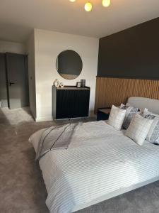 a bedroom with a large white bed with a large mirror at Ocean Breeze Apartment in Portrush