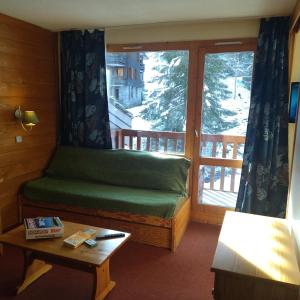 a room with a bed in front of a window at Valmorel in Valmorel