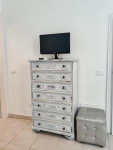 a dresser with a television on top of it at Follonica Lodging in Follonica