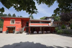 a red building with tables and chairs in front of it at La Collina Dei Castagni in Terni