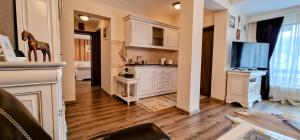 a kitchen with white cabinets and a flat screen tv at Snowflake Condo in Sinaia