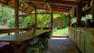 a wooden table and chairs in a pavilion with a clock at MARAMUREȘUL STRĂVECHI in Budeşti