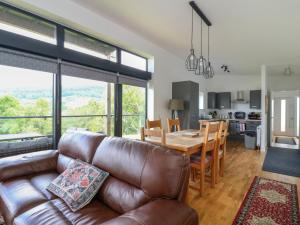 Una sala de estar con un sofá de cuero y una mesa. en 6 Strathtay Lodges, en Aberfeldy
