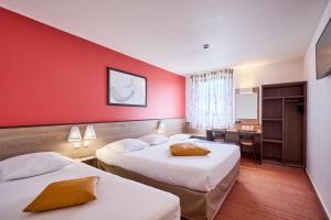 a hotel room with two beds and a desk at Ace Hôtel Caen Nord Mémorial in Caen