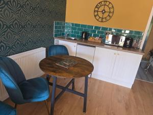 a kitchen with a table and a clock on the wall at Munnings Lodge Apartment in Mendham