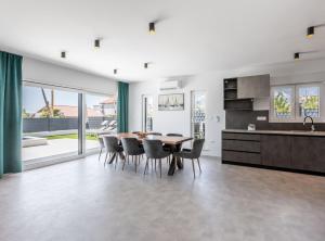 una cucina e una sala da pranzo con tavolo e sedie di Villa Bonce a Kaštela (Castelli) Altre 37 foto